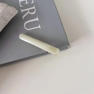 Détail d'une barrette en acétate vert pâle avec l'inscription dorée Barrette la France