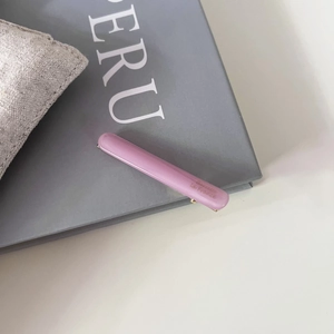 Vue détaillée d'une barrette à cheveux en acétate lilas sur un livre gris