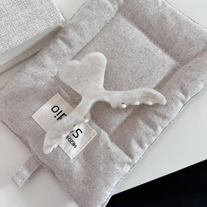 Détail macro de la pince à cheveux en acétate en forme de cœur avec logo fait main
