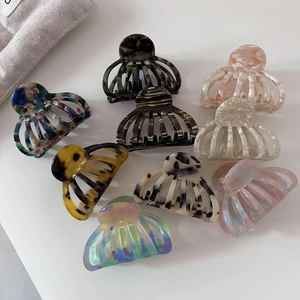 Macro detail of nine medium acetate hair claw clips with tortoiseshell and marble patterns