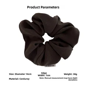 Detail view of coffee brown corduroy scrunchie with 14cm diameter and ribbed texture