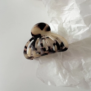 Detailed macro view of the marble pattern tortoiseshell finish on the acetate hair claw clip