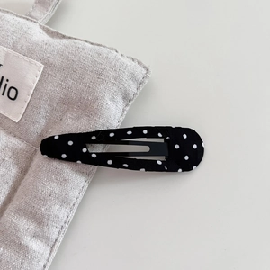 Close-up of black fabric BB hair clip with white polka dots and hollow cloud design