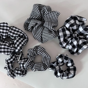 Detailed view of six black and white checkered and houndstooth pattern hair scrunchies