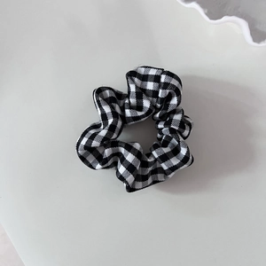Detailed view of a vintage black and white gingham scrunchie with soft fabric texture