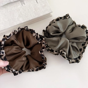 Detail of coffee and grey-green satin scrunchies with leopard print ruffled edges