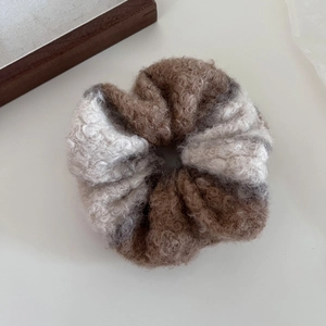 Gros plan d'un chouchou en patchwork de fausse fourrure douce marron et beige peluche