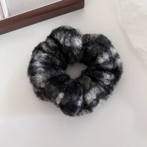 Gros plan d'un chouchou en peluche douce à carreaux gris avec texture laineuse chic