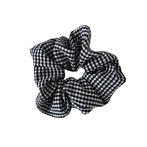Classic black and white houndstooth hair scrunchie with elegant pleated fabric texture