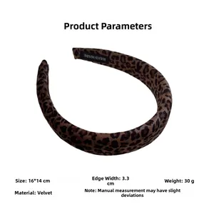 Detail view of leopard print velvet headband with handmade label and soft texture