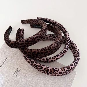 Retro leopard print velvet padded headbands in brown and pink on a book background