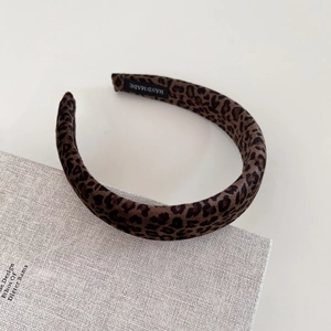 Detailed close-up of velvet leopard print headband with a black handmade label inside