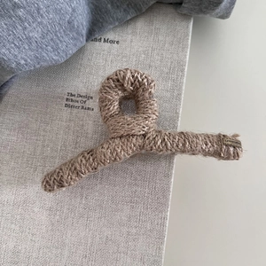 Detail einer braunen Strick-Haarklammer mit metallischem LOVEDAYS-Etikett für Damen