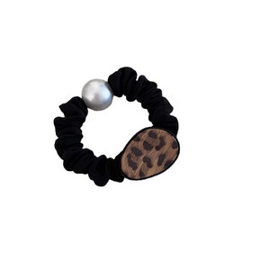 Chouchou noir élégant avec grande perle et boucle à motif léopard sur fond blanc