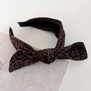 Detail of velvet leopard print headband featuring a twisted knot and soft fabric texture