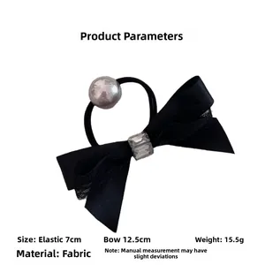 Detail of a black bow hair tie with crystal rhinestones and silver bead on white background