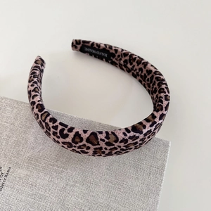 Detail of leopard print velvet headband featuring a handcrafted black inner woven label
