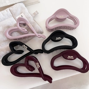 Matte heart and oval hair claw clips in pink, black, and burgundy with gold lettering