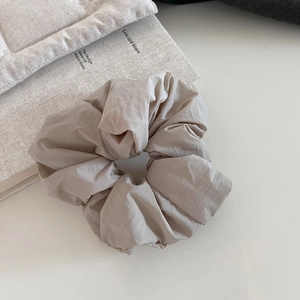 Chic beige puffer scrunchie for women with elegant pleated fabric texture and soft padding