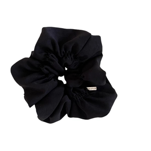 Elegant black oversized scrunchie with matte fabric texture and handmade silver label