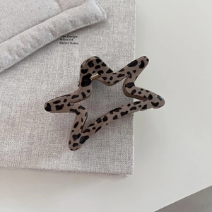 Detailed view of leopard print star hair claw clip with glossy finish and metal spring