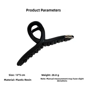 Macro view of matte black hair claw clip showing 13x5cm size and golden lettering