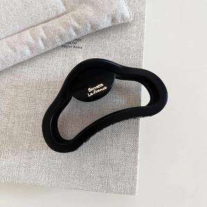 Detailed close-up of matte black shark clip with golden Barrette La France text