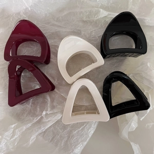 Minimalist geometric triangle and semicircle hair claws set in red, cream, and black