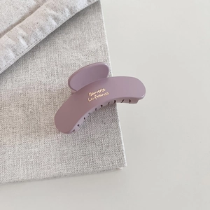 Detail showing matte purple hair claw clip with gold Barrette La France text engraving