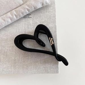 Close-up of matte black heart-shaped hair claw clip with golden Barrette La France text