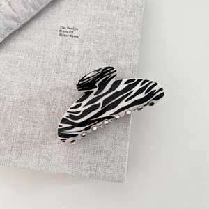 Macro shot of large zebra print hair claw clip made of glossy acetate resin material