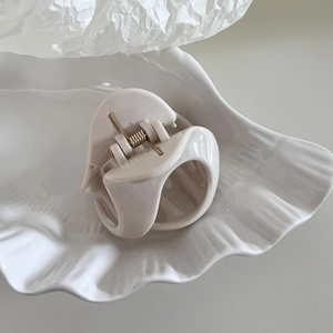 Detail view of cream-colored resin shark hair claw clip with durable metal spring mechanism