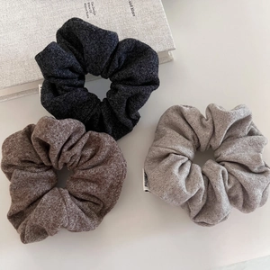 Three-piece set of oatmeal grey knitted scrunchies with soft texture and minimalist design