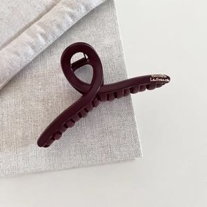 Close-up of a large burgundy matte hair claw clip with silver Barrette La France lettering
