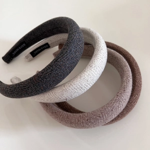 Thick wool knit padded headbands in grey, beige, and brown with a handmade label