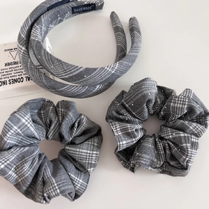 Détail d'un ensemble de serre-tête et chouchous à carreaux gris avec strass brillants