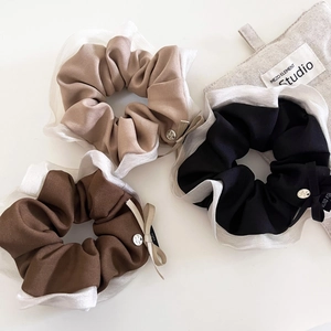Dettaglio del set di elastici per capelli con bordo in organza e fibbia in metallo