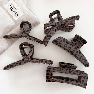 Five assorted leopard print hair claw clips in various shapes on a clean white background