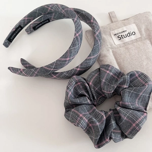 Detail view of pink and grey plaid fabric headbands and scrunchie with soft linen texture