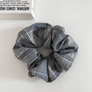 Détail d'un chouchou gris à carreaux avec texture en tissu doux et style vintage