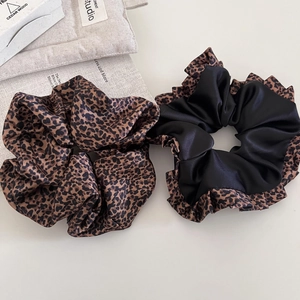 Detalle de coleteros premium con estampado de leopardo y satén negro con bordes rizados