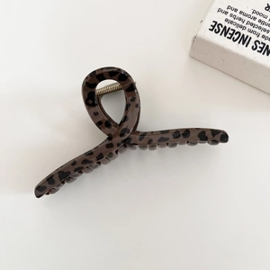 Close-up of a large leopard print hair claw clip with a strong silver metal spring