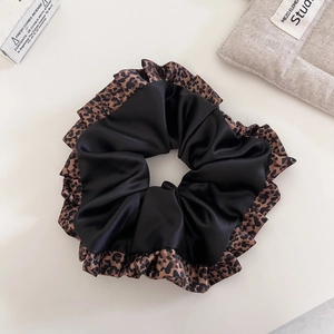 Elegante coletero de satén negro con borde de encaje de leopardo marrón sobre fondo claro