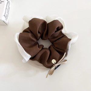 Dettaglio di elastico in tessuto con fiocco champagne, fibbia dorata e design mesh