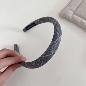 Detailed view of pink and grey plaid fabric headband with handmade textile label