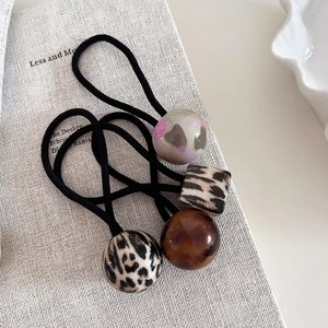 Lot de 4 chouchous avec perles à motif léopard et marbre sur une surface texturée