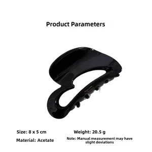 Close-up of black acetate heart hair claw with Barrette La France gold engraving