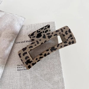 Retro leopard print acetate claw clip for thick hair shown in a minimalist setting