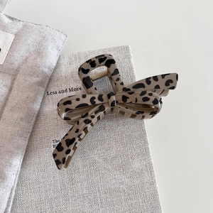 Detail of leopard print hair claw clip showing bow design and sturdy metal spring