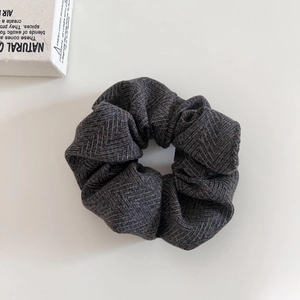 Detail shot of oversized grey and brown herringbone wool scrunchie for winter hair